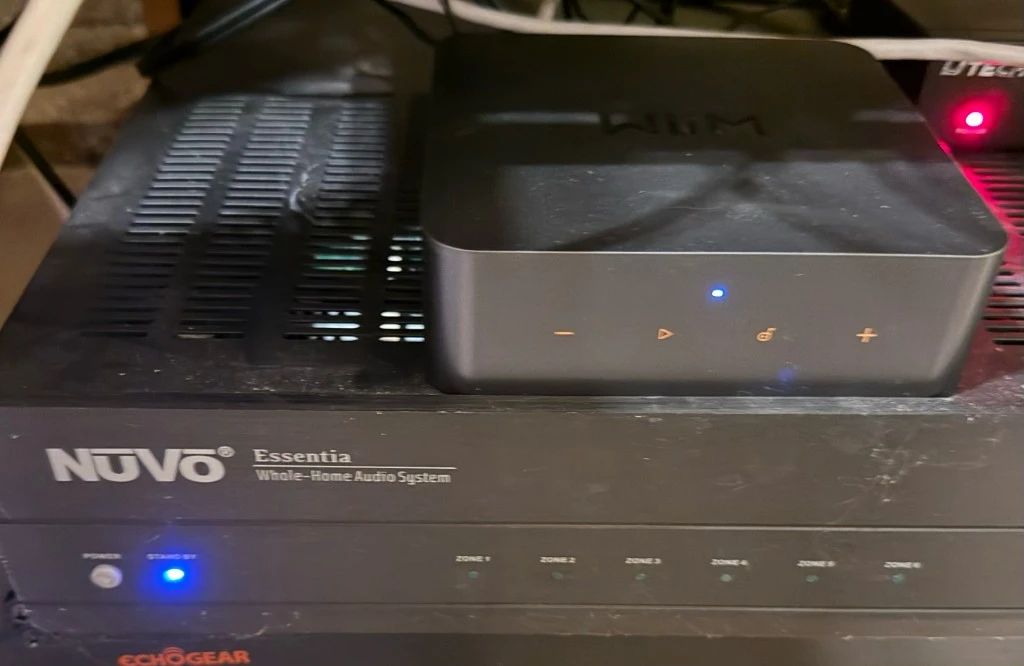 WiiM Pro streamer installed on top of a NuVo Essentia whole-home audio amplifier